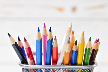 Colored pencils in pencil case  on wooden background.

