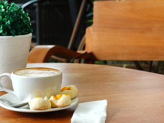 Coffee cup and macarons on woden table