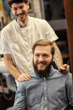 smiling male barber and satisfied customers.