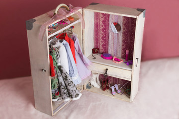 A large white chest in which the wardrobe of the doll is placed.