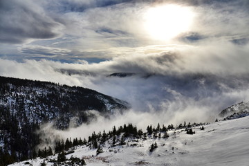 Sunbeams passing through clouds in beautiful winter landscape, Elbe valley Krkonose Mountains, Czech Republic
