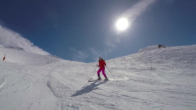 Woman Skier Skiing Down On The Ski Slope In Winter Mountains On A Sunny Day