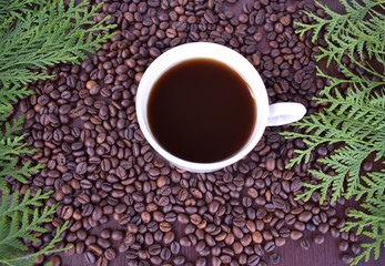 Mug with coffee beans among coffee beans