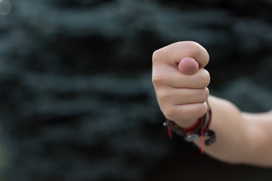 fig sign by person hand and fingers on unfocused outdoor background, copy space