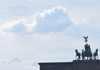 Brandenburger Tor am Pariser Platz in Berlin vor hellblauem Hintergrund und Wattewolken © Manuela