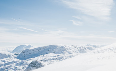 Snowy winter landscape in the Austrian Alps. Rocky plateau covered by sunlight. Bright white light reflected by snow