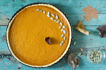 Traditional American pumpkin pie for Thanksgiving Day or Halloween on a wooden background. Rustic...
