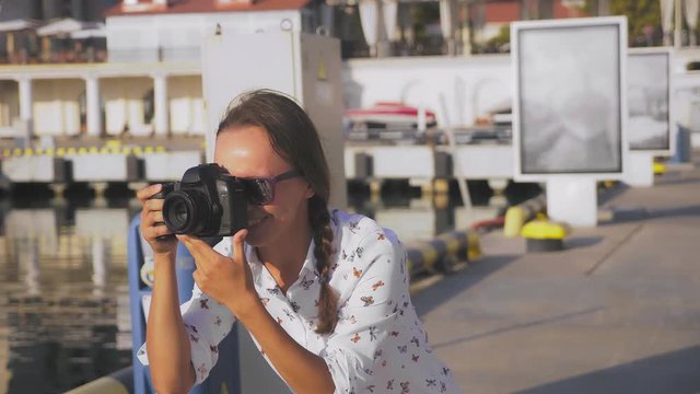 professional photographer, pictures in the seaport against the backdrop of yachts, a woman presses a button and talks to the model. 4k, slow motion,