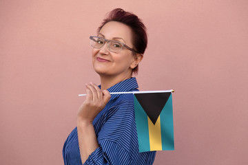 Bahamas flag. Woman holding The Bahamas flag. Nice portrait of middle aged lady 40 50 years old...