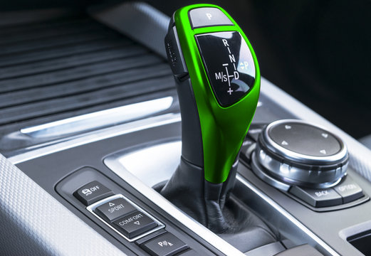 Green Automatic gear stick of a modern car. Modern car interior details. Close up view. Car detailing. Automatic transmission lever shift. Black leather interior with stitching.