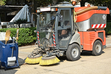 Street cleaner vehicle and garbage can on the road