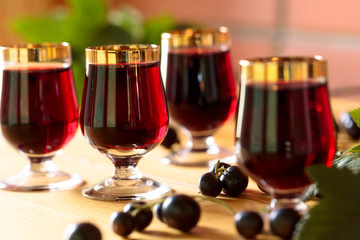Homemade black currant liqueur and fresh berries.