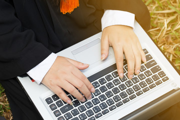 Hands of graduated in gown working with laptop feeling so proud and happiness in Commencement day,Education Success Concept