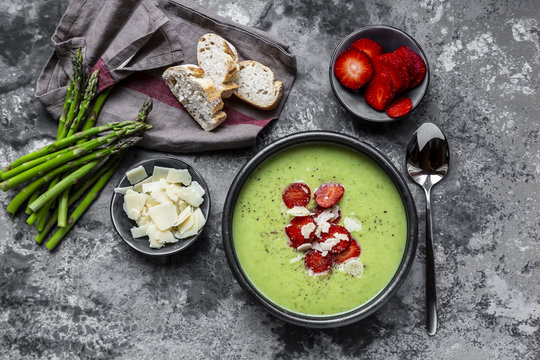 Green asparagus cream soup with strawberry, parmesan and baguette