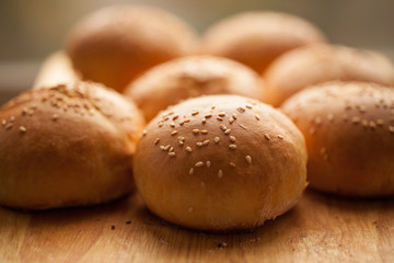 background of homemade buns with sesame seeds for hamburgers. made at home bread. natural product.
