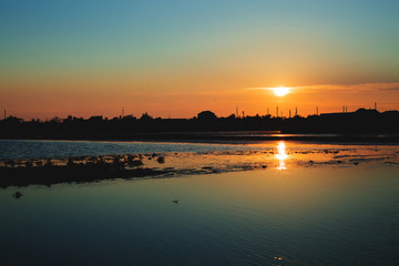 silhouette of a landing-stage and wood as the sunsets on lower.