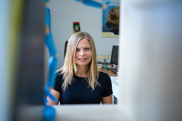 Young businesswoman with her computer, working in the coworking preparing her business idea