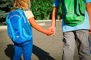 little boy and girl holding hands go to school