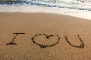 write I love you on the sand with the wave