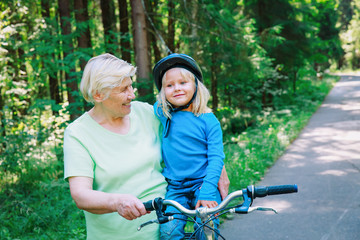 grandmother teaching little granddaughter to ride bike