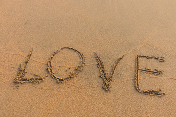 The word love written on the sand.