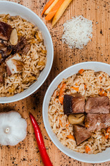 pilaf in a plate on wooden background, top view, copy space -