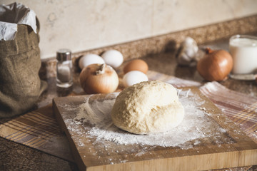 piece of dough lies on board of flour