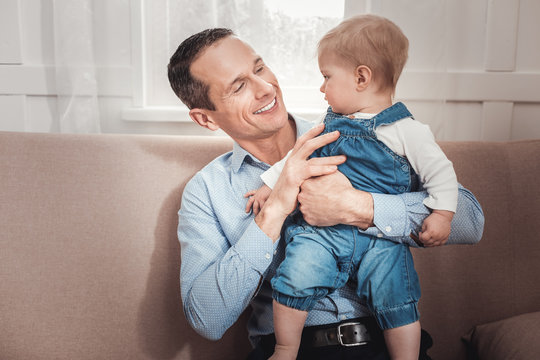 My dear son. Joyful positive man smiling to his baby while feeling happy