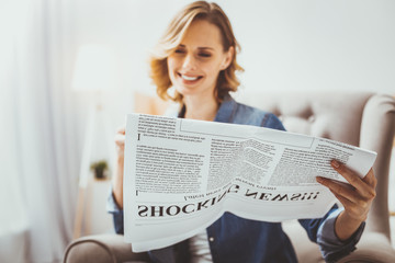 Shocking news. Happy blonde keeping smile on her face while spending morning with pleasure