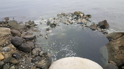Dirty water comes from sewer pipe in the sea