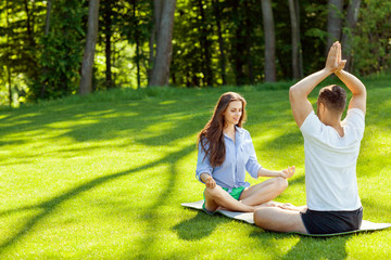 girl in park doing yoga with their teacher