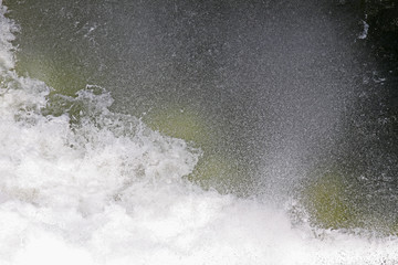 Splashes and spray from waterfall. Big water splash in lake after diving. Splash water on the river, beautiful colorful bright splash. Dam waterfalls with big diving splashes. Water splash background.