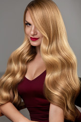 Fototapeta premium Styl włosów. Piękna Kobieta Z Zdrowe Falowane Długie Blond Włosy