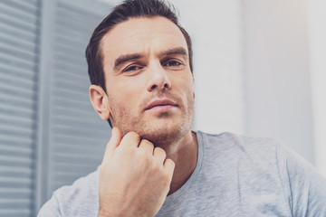 Occupied man. Handsome dark-haired man feeling very occupied while working on complicated business plan