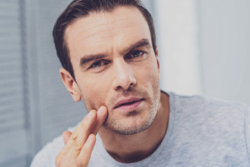 Thoughtful man. Handsome mature dark-haired man wearing stylish grey shirt feeling thoughtful after long busy day