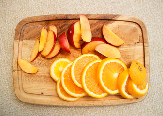 Photo of nectarines and orange on wooden rain