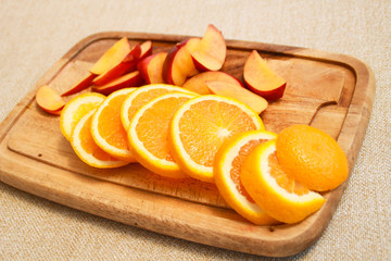 Photo of nectarines and orange on wooden rain