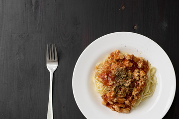 Spaghetti on black wooden background