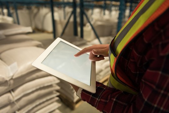 Female worker using digital tablet at warehouse
