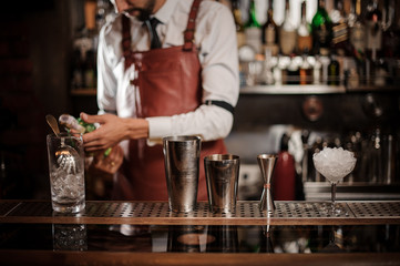 Bartender holding a bottle of alcoholic drink on the bar counter