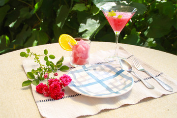 Photo of watermelon cocktails with roses on table with plate.