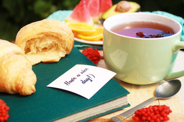 Morning flat lay with croissants,cup of tea ans fruits.
