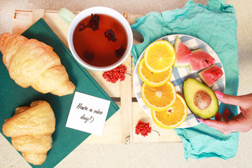 Morning flat lay with croissants,cup of tea ans fruits.