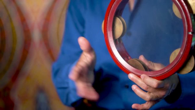 Closeup of hands playing bills on clear riq with slow rhythm.