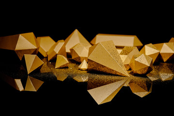 close-up view of shiny golden glittering pieces of gold reflected on black