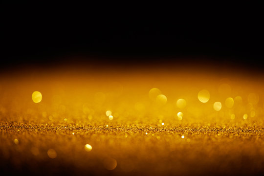 sparking gold glitter with bokeh on black background