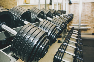 Heavy dumbbells lying in the raw in the gym. Fitness sport motivation. Happy healthy lifestyle living. Exercises with bars weights.