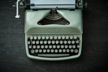 beautiful old gray typewriter on a black wooden table