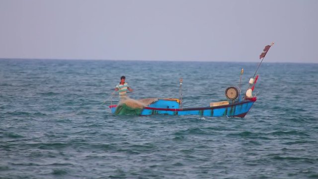 South China Sea, Nha Trang, Central Vietnam, Asia, August 26 2018. Vietnamese fishing boats navigating across the South China Sea, deep sea fishing in wooden boats casting fishing nets.