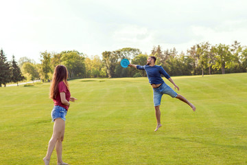 couple in love playing frisbee in the park, the concept of a healthy lifestyle.
